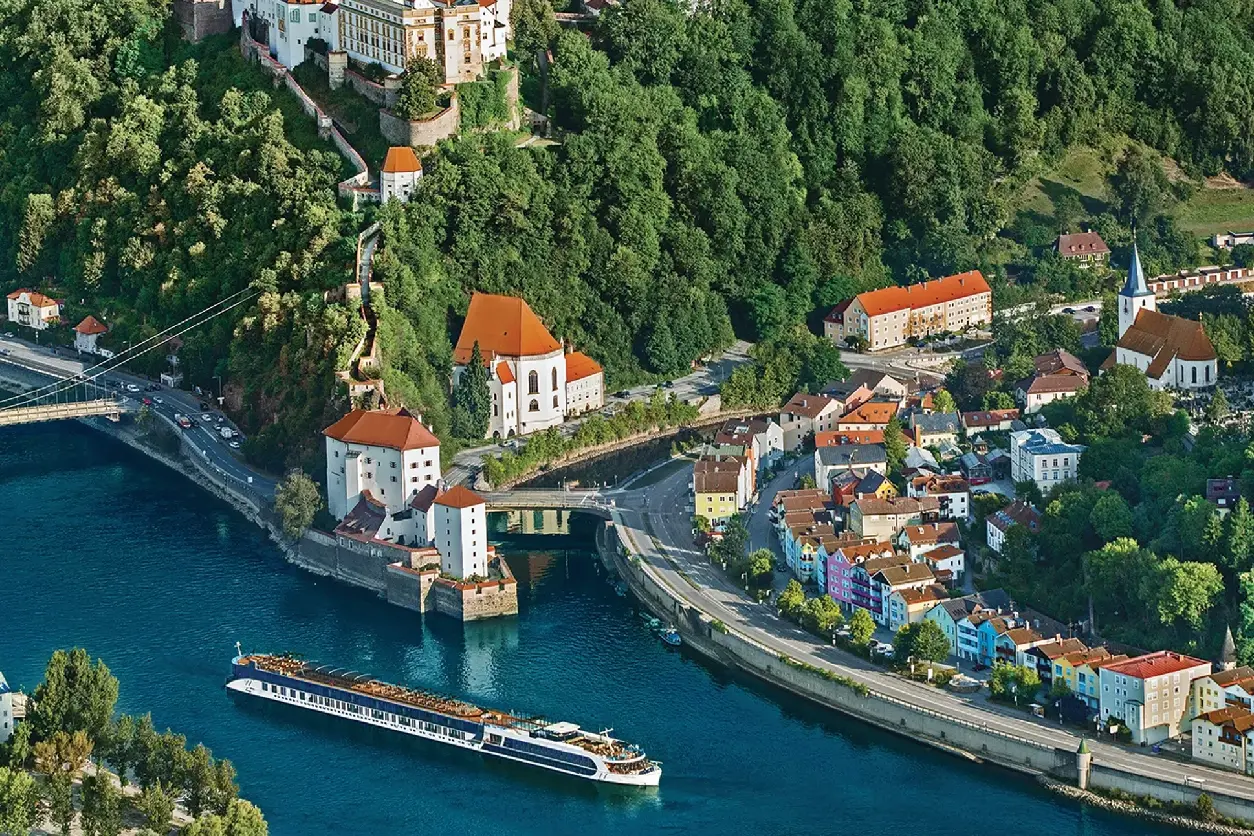 A boat is traveling down the river near some buildings.